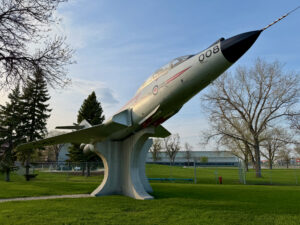 Air Force Heritage Air Park, Winnipeg: Planes, History and Coffee 25 Decommissioned CF-101B Voodoo jet aircraft mounted on a concrete pedestal in a public park, with bare trees and green grass surrounding it