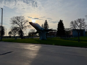 Air Force Heritage Air Park, Winnipeg: Planes, History and Coffee 26 Large fighter jet sculpture mounted on a pedestal in a public park at sunset, with bare trees and evergreens surrounding the installation