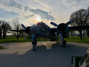 Air Force Heritage Air Park, Winnipeg: Planes, History and Coffee 53 Vintage twin-engine aircraft with number 51 on fuselage, displayed on brick platform in park setting with bare trees and cloudy sky