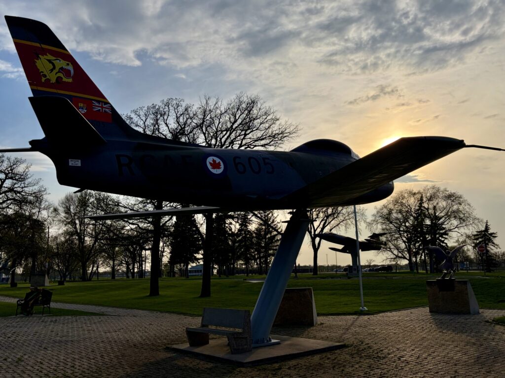Air Force Heritage Air Park, Winnipeg: Planes, History and Coffee 40 Silhouette of a Canadian Armed Forces jet aircraft mounted on a display stand in a park, with bare trees and cloudy sky in the background