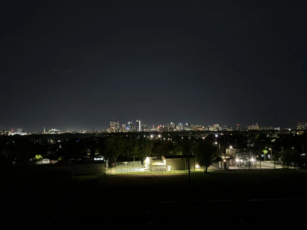 City skyline at night with lights from buildings and streetlights visible
