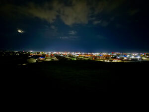 Westview Off-Leash Dog Park: Winnipeg's "Garbage Hill" and the First Park We Ever Walked in Canada 17 Panoramic view of a city at night, with lights twinkling in the distance under a cloudy sky