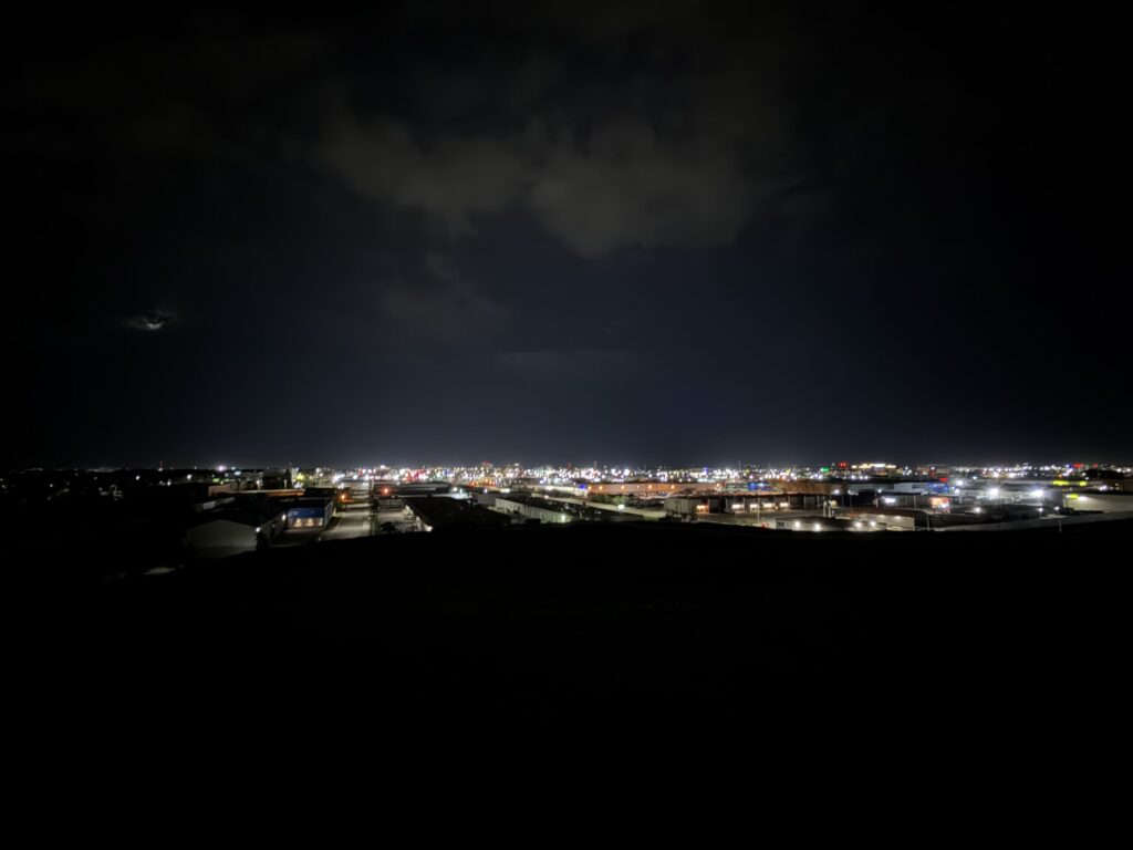 Westview Off-Leash Dog Park: Winnipeg's "Garbage Hill" and the First Park We Ever Walked in Canada 5 Distant cityscape at night with lights illuminating buildings and roads under a cloudy sky