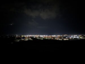Westview Off-Leash Dog Park: Winnipeg's "Garbage Hill" and the First Park We Ever Walked in Canada 15 Distant cityscape at night with lights illuminating buildings and roads under a cloudy sky