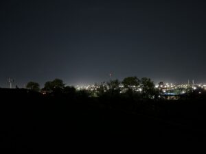 Westview Off-Leash Dog Park: Winnipeg's "Garbage Hill" and the First Park We Ever Walked in Canada 12 Silhouetted trees and a distant city skyline illuminated by lights at night