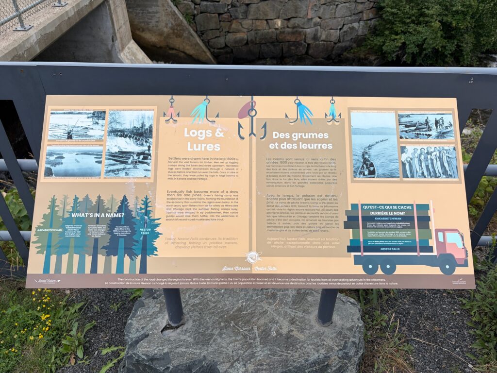 Interpretive sign describing the history of logging and fishing at Nestor Falls, with sections on logs and lures, fish species, and the region's development from settlement to modern tourism destination